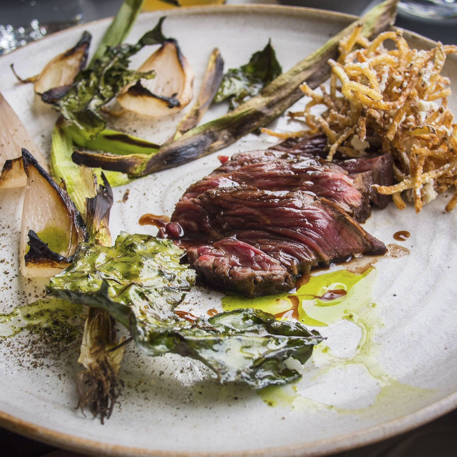 Steak onglet, salmuera, charred onion, and chicken fat curly fries, at Pidgin